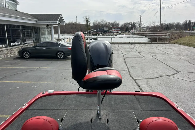Slide: The Image of 2007 Skeeter 20i boat with red and black seating, parked near a waterfront. - 30