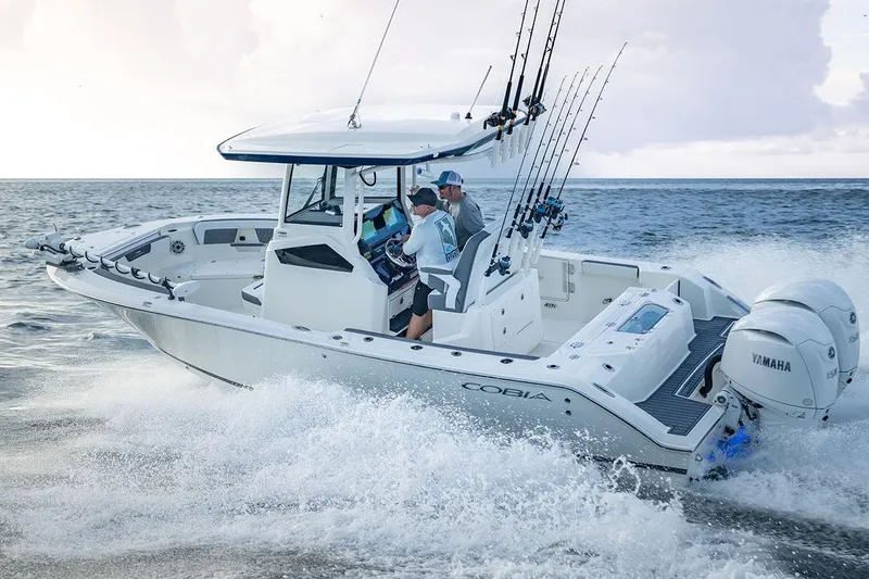 Slide: The Image of Manufacturer Provided Image: 2026 Cobia 245 Center Console boat cruising on ocean with fishing rods and Yamaha engines. - 3