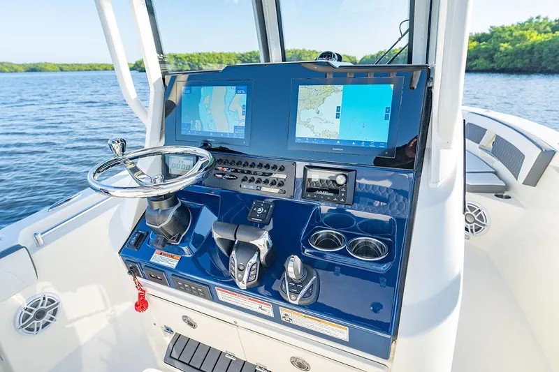Slide: The Image of Manufacturer Provided Image: 2026 Cobia 245 Center Console boat dashboard with navigation screens and controls. - 9