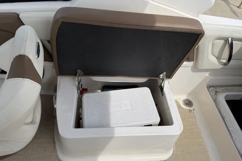 Slide: The Image of Open storage compartment with cooler on 2014 Chaparral 257 SSX boat interior. - 13
