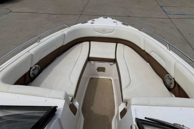 Slide: The Image of 2014 Chaparral 257 SSX boat interior with white and brown seating, speakers, and carpeted floor. - 20