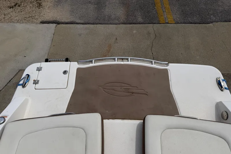 Slide: The Image of 2014 Chaparral 257 SSX boat deck with logo, featuring white and brown design. - 31