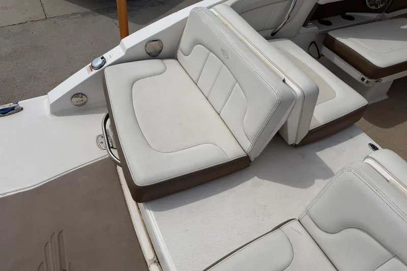 Slide: The Image of 2014 Chaparral 257 SSX boat interior with white and brown seating arrangement. - 33