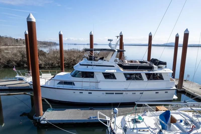 The Image of 1986 Hatteras 63 Motor Yacht docked at a serene marina. - 1