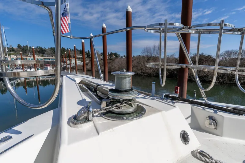 Slide: The Image of 1986 Hatteras 63 Motor Yacht bow with anchor chain and American flag, docked in marina. - 101