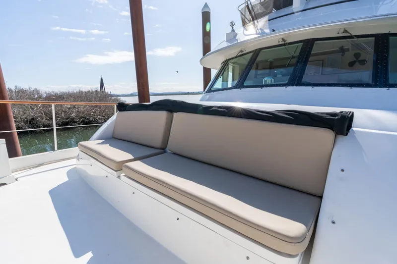 Slide: The Image of 1986 Hatteras 63 Motor Yacht deck with cushioned seating under clear skies. - 103