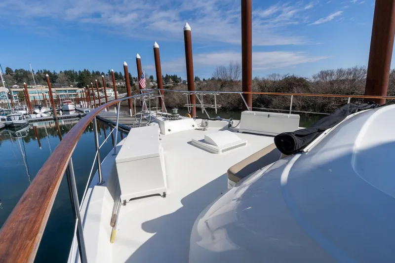Slide: The Image of 1986 Hatteras 63 Motor Yacht deck view at marina, clear sky, calm water. - 104