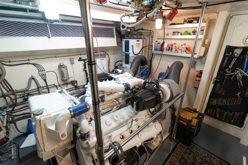 Slide: The Image of Engine room of a 1986 Hatteras 63 Motor Yacht, showcasing machinery and tools. - 114