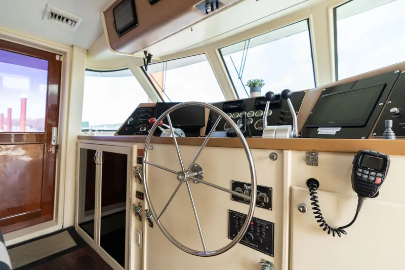 Slide: The Image of Interior helm of 1986 Hatteras 63 Motor Yacht with steering wheel and navigation controls. - 117