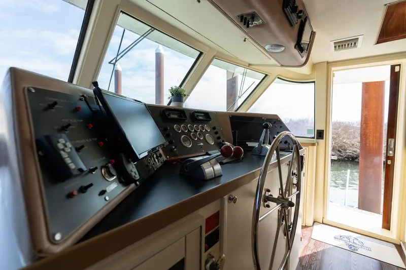 Slide: The Image of 1986 Hatteras 63 Motor Yacht helm with steering wheel and navigation controls. - 118