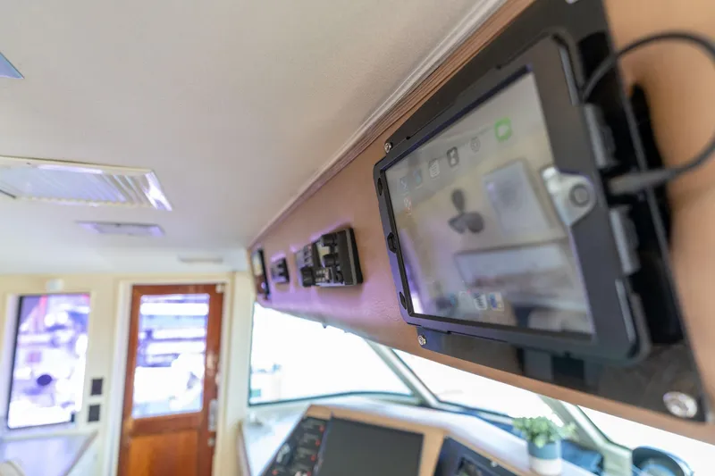 Slide: The Image of Interior of 1986 Hatteras 63 Motor Yacht with modern control panel and wooden accents. - 125