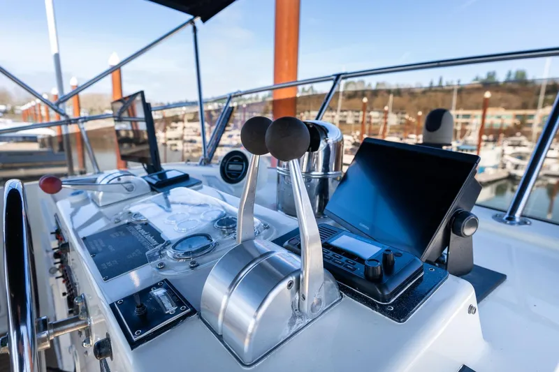 Slide: The Image of Control panel of a 1986 Hatteras 63 Motor Yacht, featuring navigation equipment and throttle levers. - 132