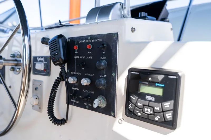 Slide: The Image of Control panel of a 1986 Hatteras 63 Motor Yacht with steering wheel and radio system. - 134