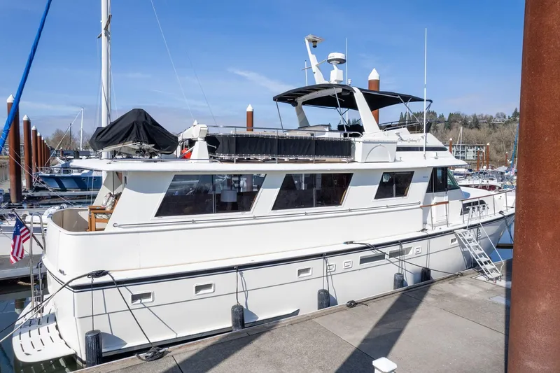 Slide: The Image of 1986 Hatteras 63 Motor Yacht docked at marina under clear blue sky. - 144