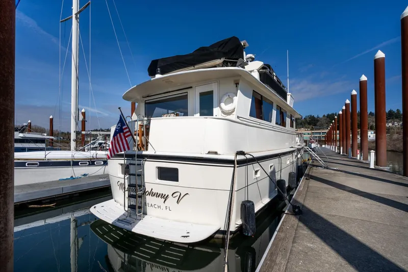 Slide: The Image of 1986 Hatteras 63 Motor Yacht docked at marina under clear blue sky. - 151