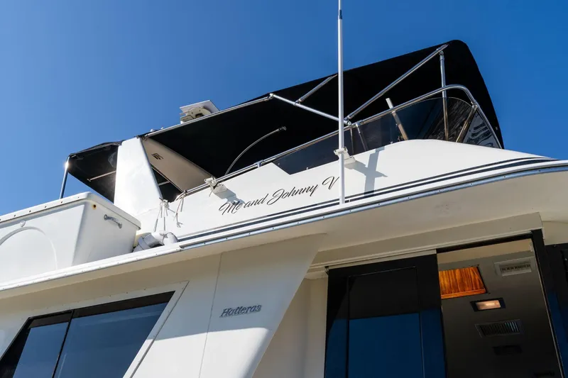 Slide: The Image of 1986 Hatteras 63 Motor Yacht with black canopy against clear blue sky. - 152
