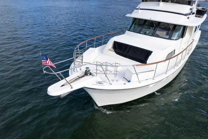 Slide: The Image of 1986 Hatteras 63 Motor Yacht cruising on open water with American flag. - 162