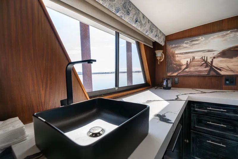 Slide: The Image of Luxurious kitchen interior of 1986 Hatteras 63 Motor Yacht with modern sink and scenic artwork. - 17