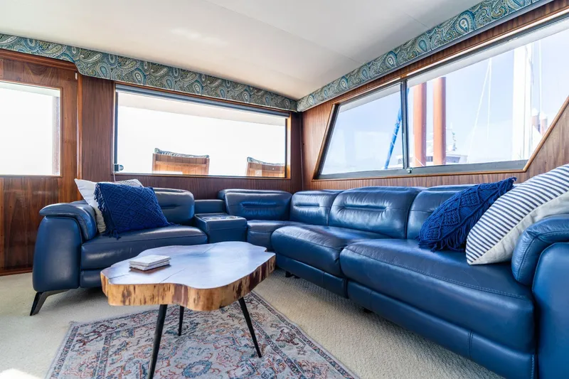 Slide: The Image of Luxurious interior of 1986 Hatteras 63 Motor Yacht with blue leather seating and wooden accents. - 23