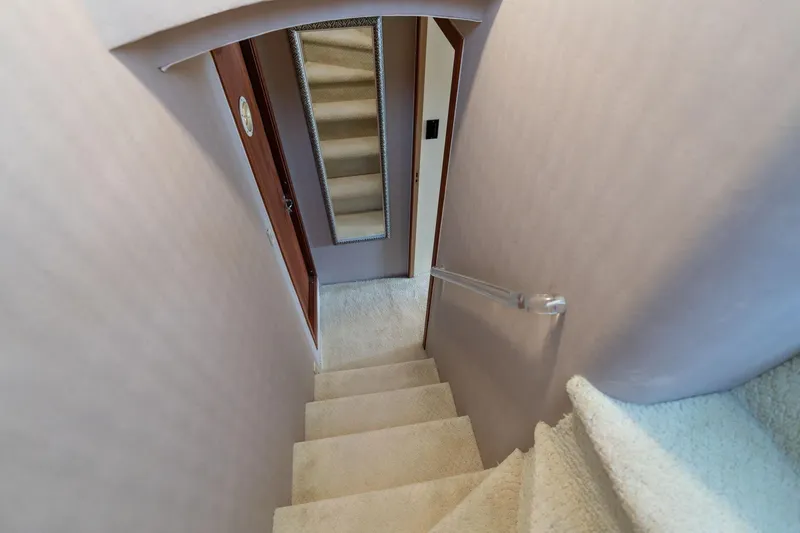 Slide: The Image of Interior staircase of 1986 Hatteras 63 Motor Yacht, featuring carpeted steps and a wall mirror. - 33