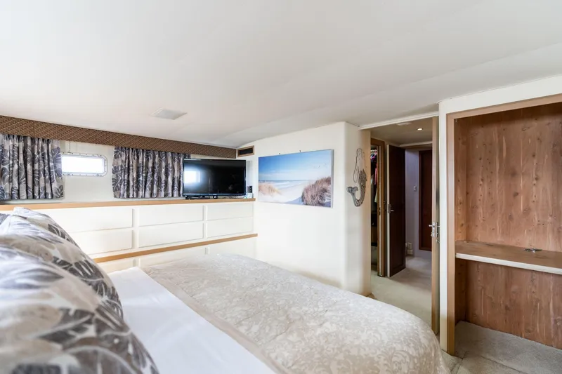 Slide: The Image of Bedroom interior of 1986 Hatteras 63 Motor Yacht with TV, artwork, and elegant decor. - 35