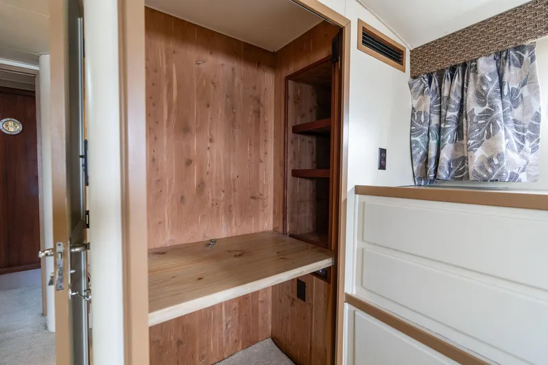 Slide: The Image of Interior of 1986 Hatteras 63 Motor Yacht with wooden closet and floral curtains. - 40