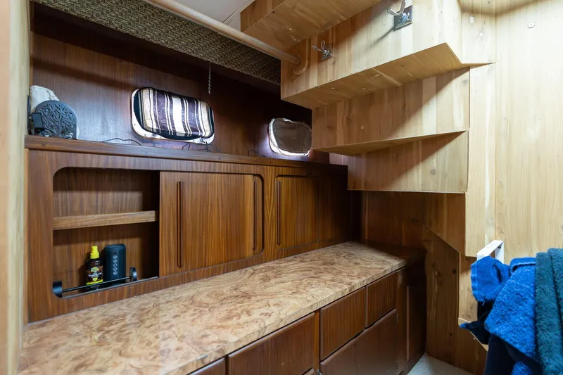 Slide: The Image of Interior of 1986 Hatteras 63 Motor Yacht with wooden cabinetry and storage shelves. - 42