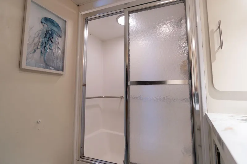 Slide: The Image of Bathroom with frosted glass shower door and jellyfish artwork on Hatteras 63 Motor Yacht. - 44