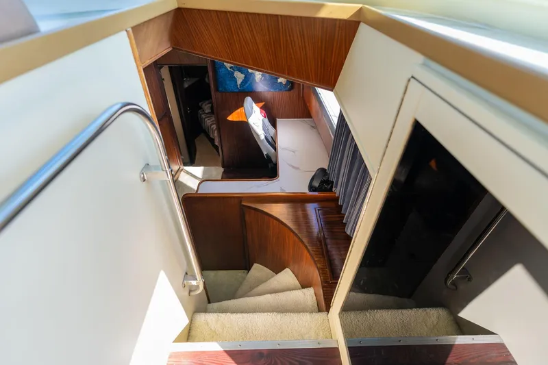 Slide: The Image of Interior view of 1986 Hatteras 63 Motor Yacht, featuring a staircase and cozy cabin area. - 47