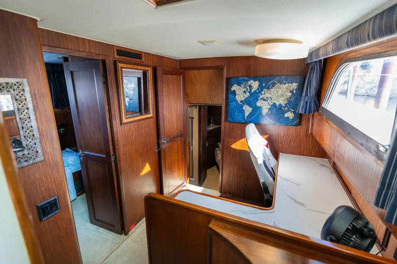 Slide: The Image of Interior of 1986 Hatteras 63 Motor Yacht with wood paneling and world map decor. - 48