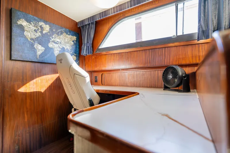 Slide: The Image of Interior of 1986 Hatteras 63 Motor Yacht with desk, chair, and world map decor. - 50