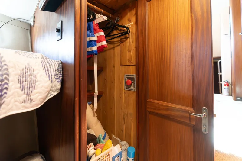 Slide: The Image of Interior of 1986 Hatteras 63 Motor Yacht showing wooden closet and storage area. - 55