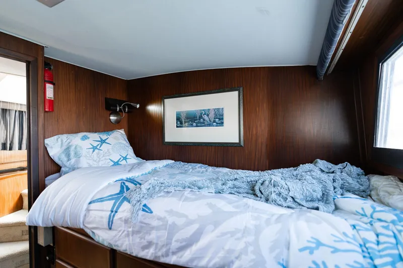 Slide: The Image of Cozy cabin interior of 1986 Hatteras 63 Motor Yacht with nautical-themed bedding. - 58
