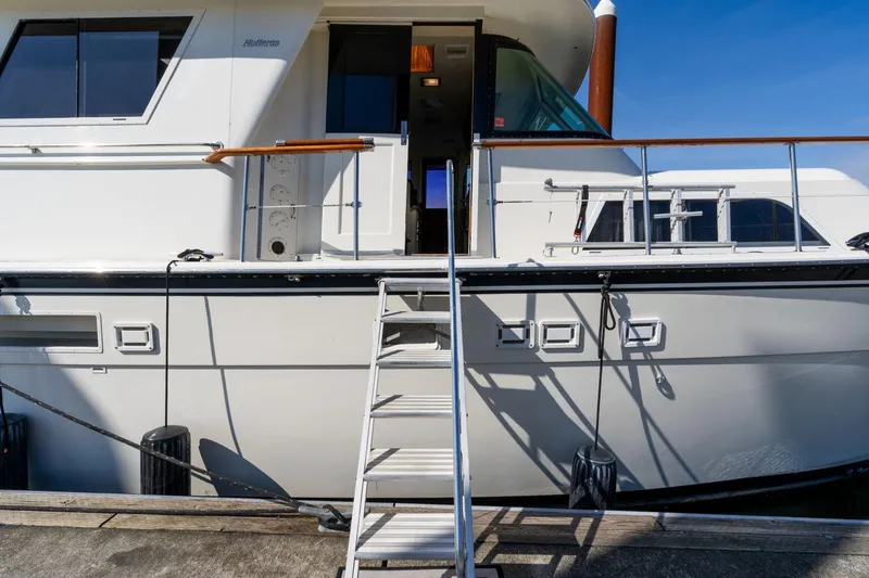 Slide: The Image of 1986 Hatteras 63 Motor Yacht docked with boarding ladder and open cabin door. - 6