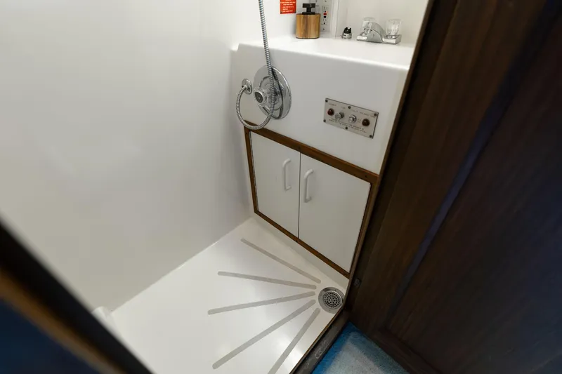 Slide: The Image of Shower area in 1986 Hatteras 63 Motor Yacht with white cabinetry and fixtures. - 63