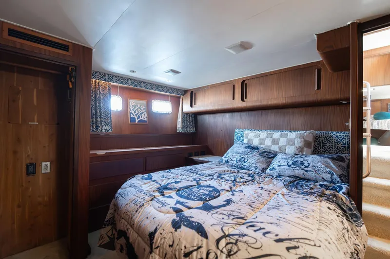 Slide: The Image of Bedroom interior of 1986 Hatteras 63 Motor Yacht with nautical-themed bedding. - 64