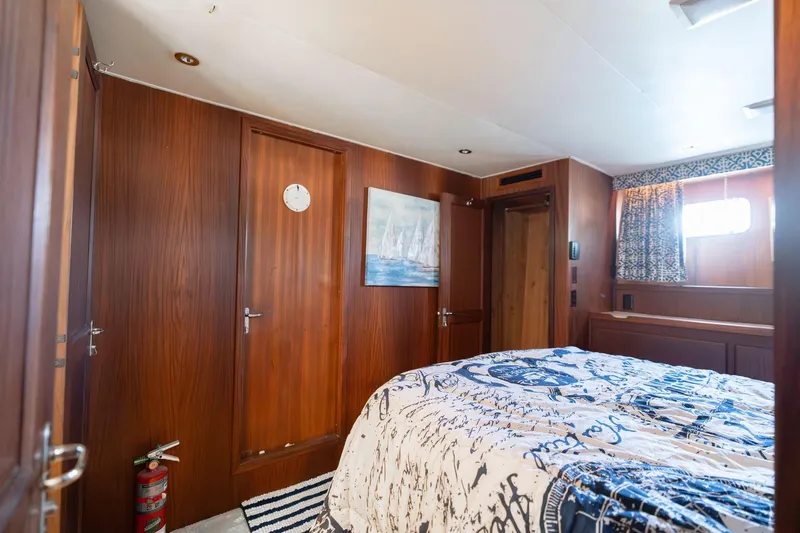 Slide: The Image of Bedroom interior of 1986 Hatteras 63 Motor Yacht with nautical decor and wood paneling. - 65