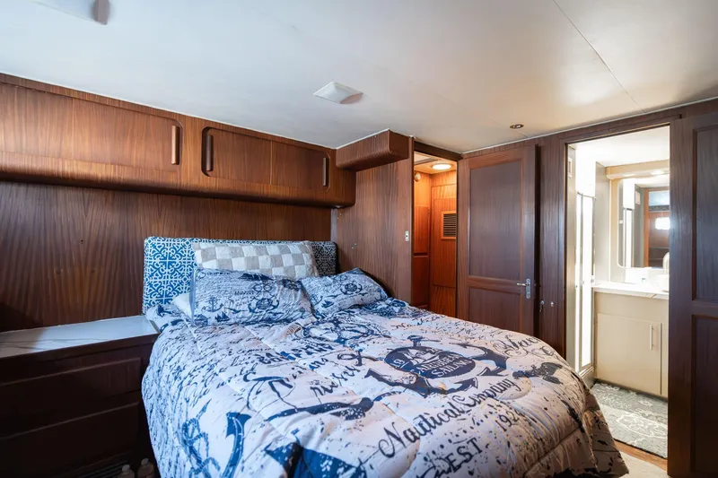 Slide: The Image of Bedroom interior of 1986 Hatteras 63 Motor Yacht with nautical-themed bedding. - 66