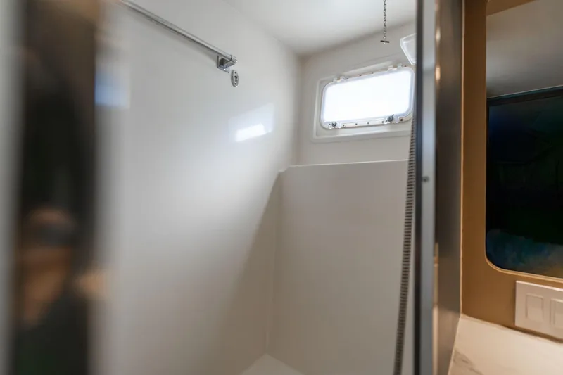 Slide: The Image of Interior of 1986 Hatteras 63 Motor Yacht bathroom with window and shower area. - 69