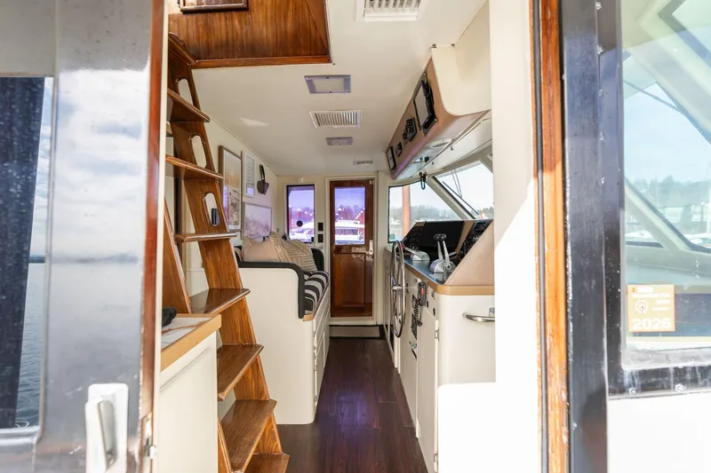 Slide: The Image of Interior view of 1986 Hatteras 63 Motor Yacht, showcasing helm and wooden staircase. - 7