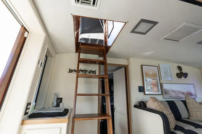 Slide: The Image of Interior of 1986 Hatteras 63 Motor Yacht with wooden ladder and cozy seating area. - 74