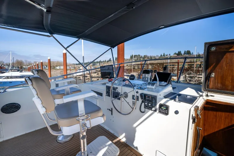 Slide: The Image of 1986 Hatteras 63 Motor Yacht helm with dual seats and navigation controls. - 77