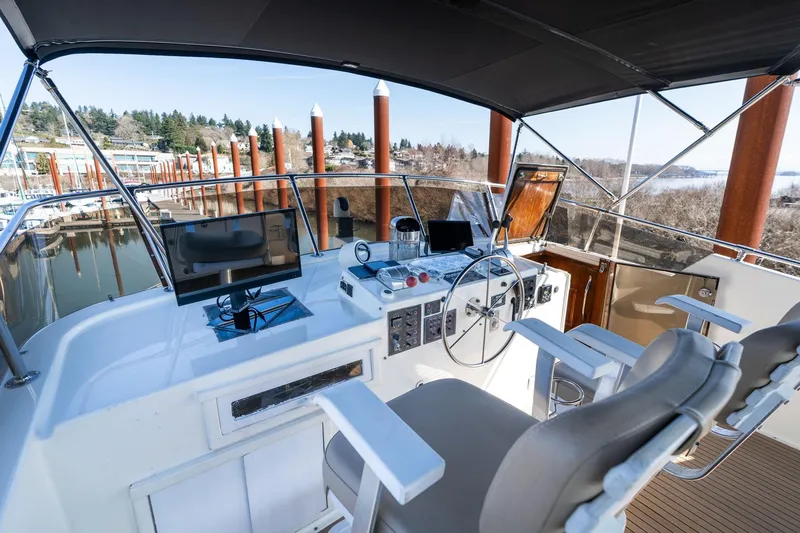 Slide: The Image of 1986 Hatteras 63 Motor Yacht helm with modern navigation equipment and comfortable seating. - 80