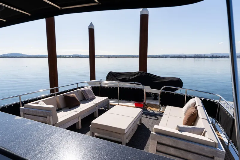 Slide: The Image of Spacious deck of 1986 Hatteras 63 Motor Yacht with comfortable seating and scenic water view. - 85