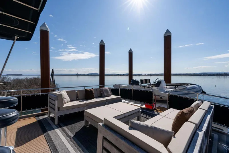 Slide: The Image of Luxurious deck of 1986 Hatteras 63 Motor Yacht with elegant seating and scenic water view. - 89