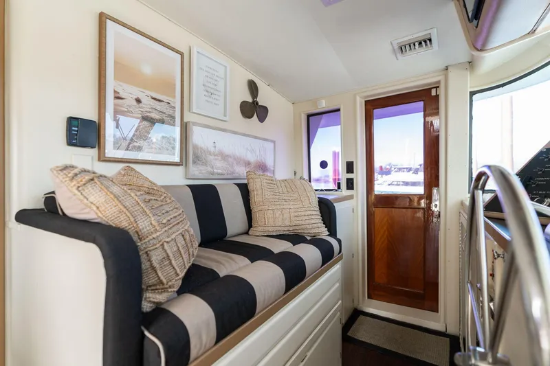 Slide: The Image of Interior of 1986 Hatteras 63 Motor Yacht with striped sofa and nautical decor. - 9