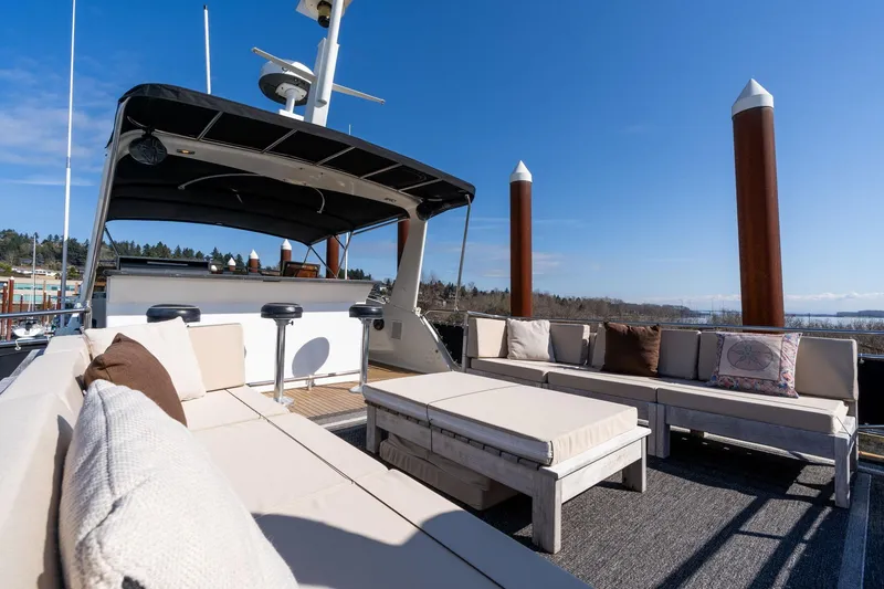 Slide: The Image of 1986 Hatteras 63 Motor Yacht deck with comfortable seating under clear blue sky. - 90