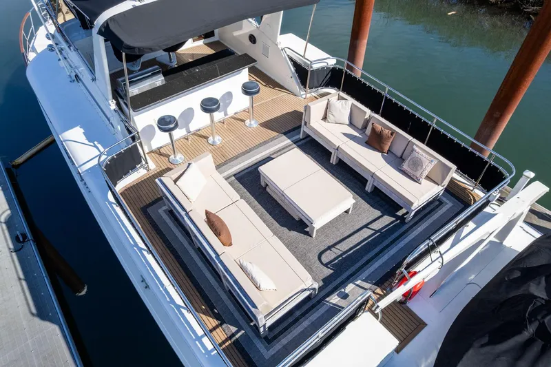 Slide: The Image of Luxurious 1986 Hatteras 63 Motor Yacht with spacious outdoor seating and bar area. - 91