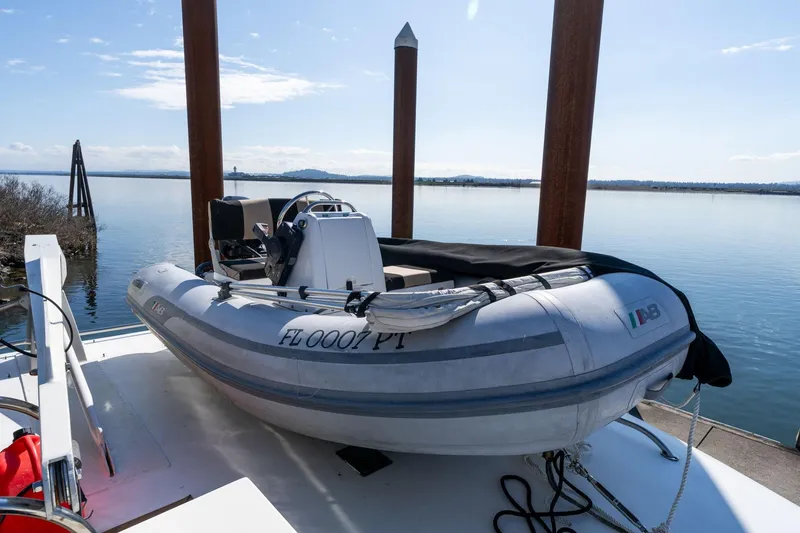 Slide: The Image of Inflatable boat on 1986 Hatteras 63 Motor Yacht, docked by calm waters. - 93