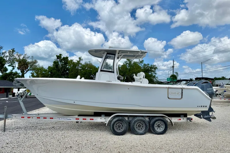 The Image of 2018 Sea Hunt Gamefish 27 boat on trailer under blue sky. - 0